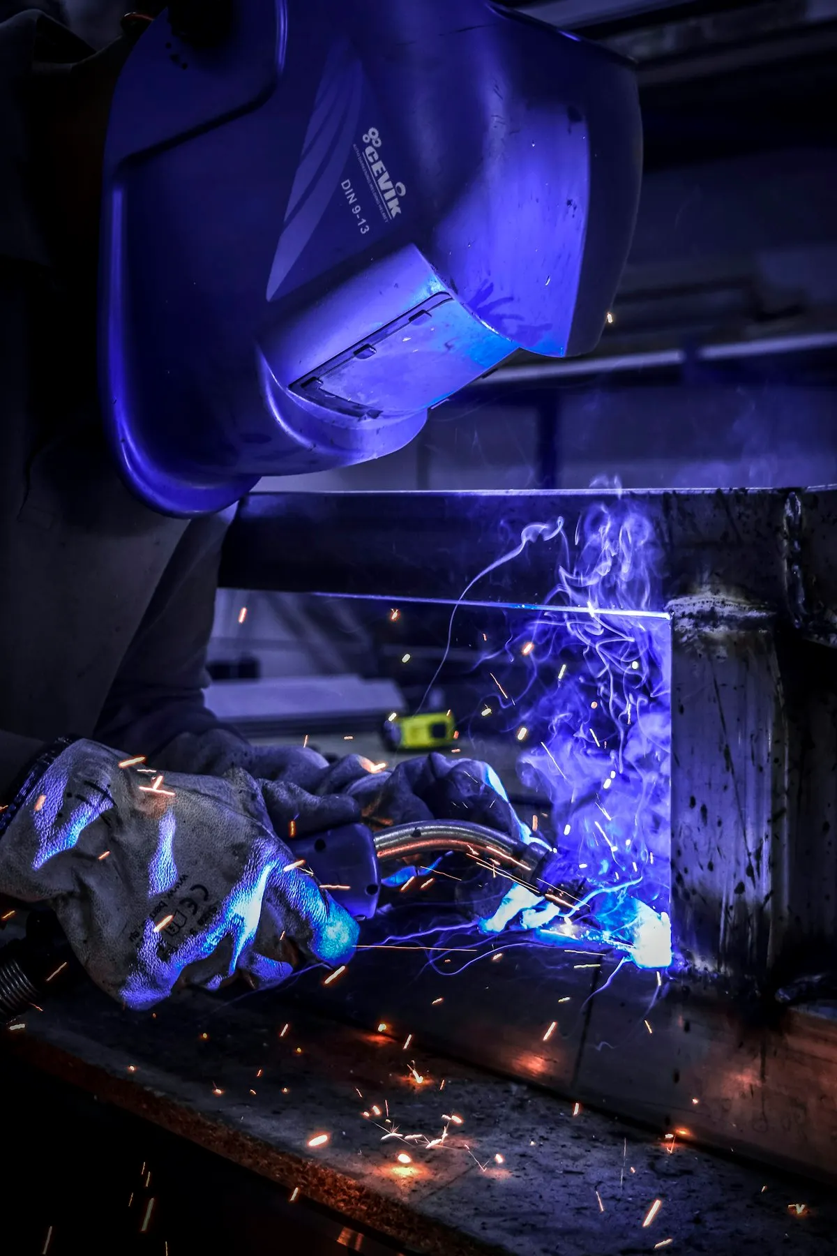 Welder joining a metal frame with a bright arc